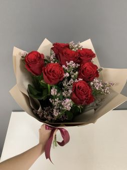 букет из красных роз в крафт бумаге