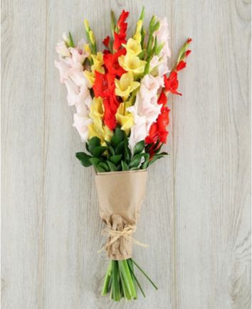 Букет с разноцветными гладиолусами в крафт бумаге